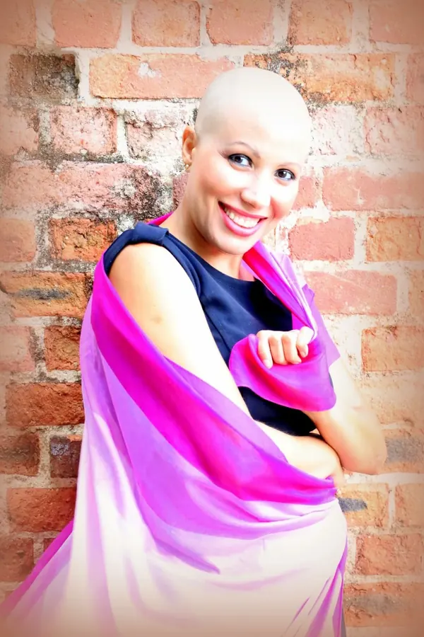 Patrícia durante a quimioterapia, sorrindo, com o lenço rosa